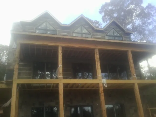 Dormers and porch framing on a large log home under construction — Roof Coating work by our crew in Schoharie