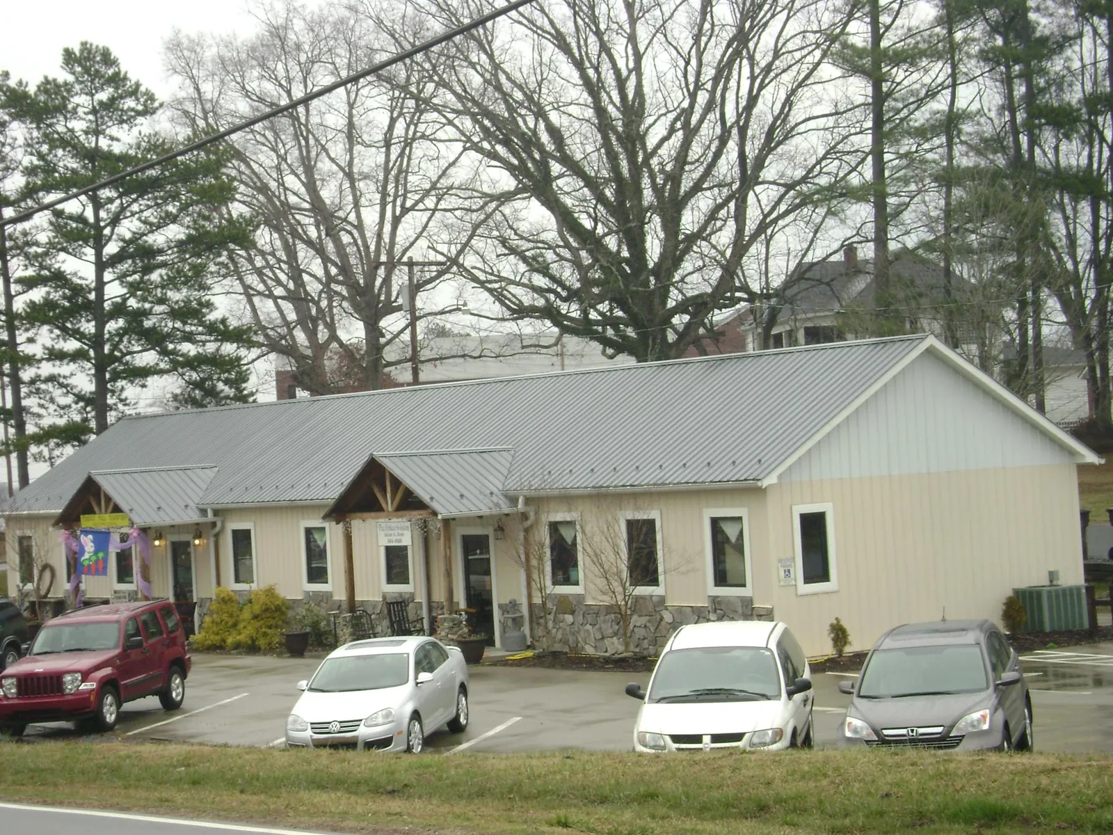 Gray metal roof with timber entry brackets on a small commercial building in Schoharie