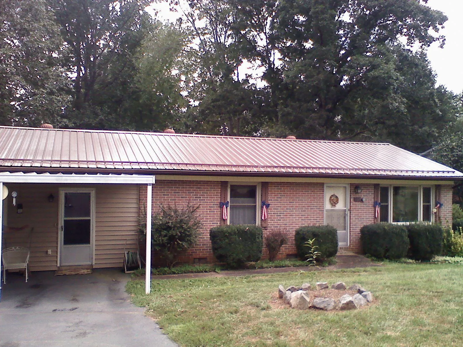 Bronze metal roof and carport on a brick ranch home — Roof Repair work by our crew in Schoharie